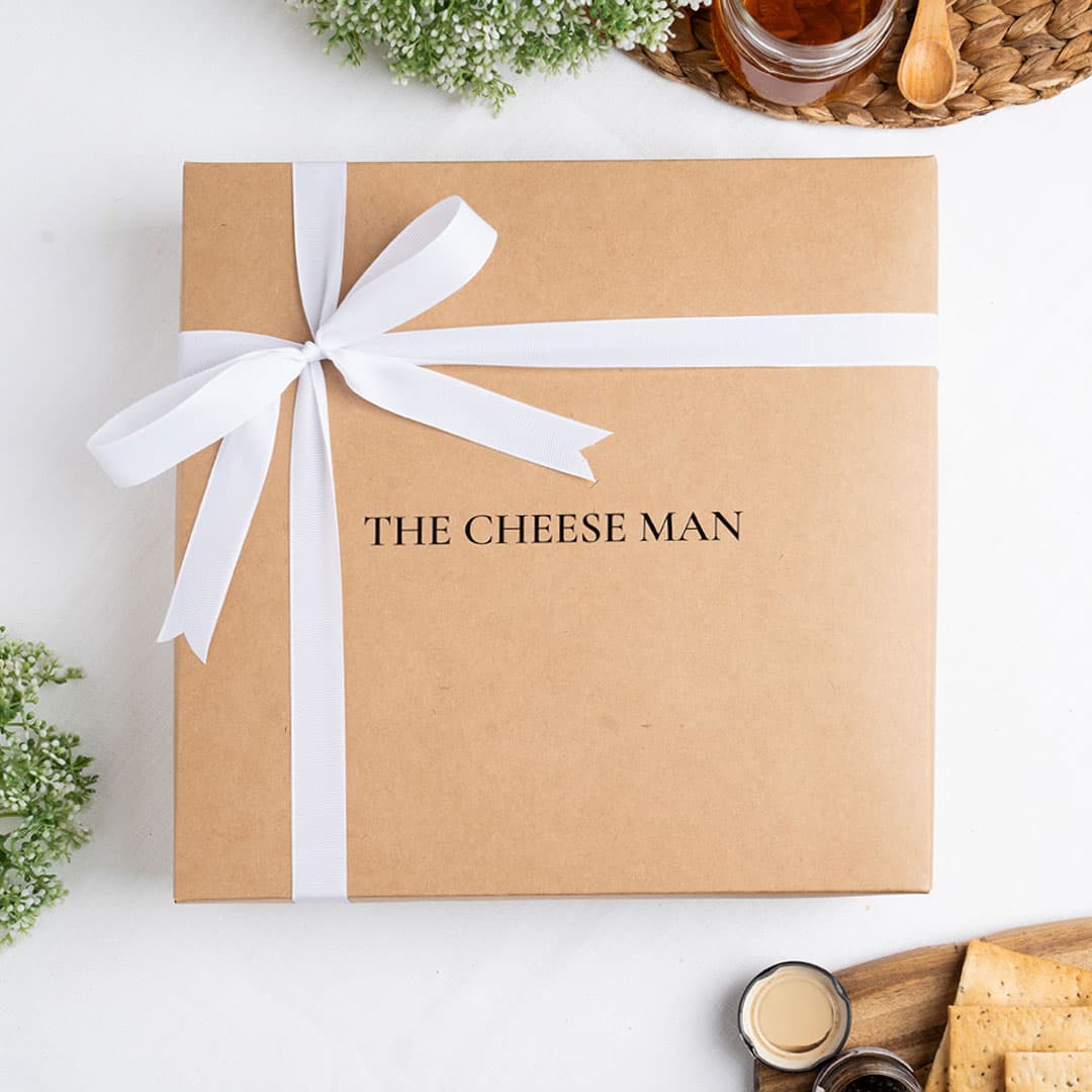 The Cheese Man luxury gift box packaging with elegant ribbon presentation, designed for gourmet cheese hampers, cheese platters, and charcuterie board gifting in Dubai.