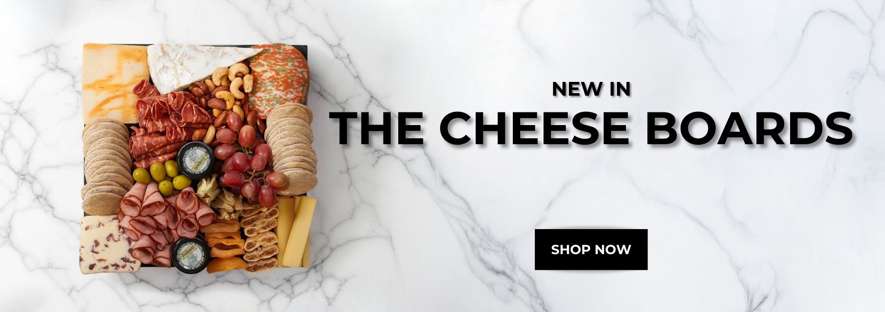 Cheese board with meats, fruits, and nuts.