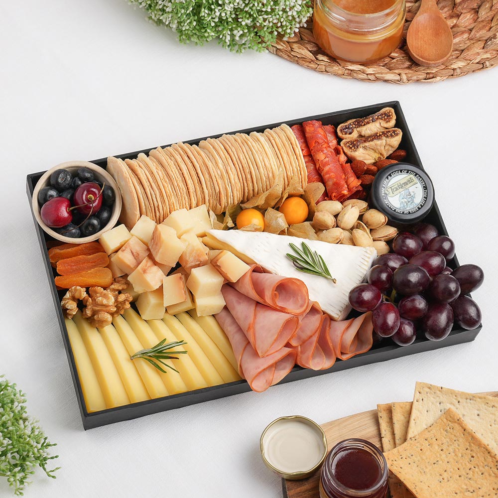 The Premium Cheeseboard Small is a gourmet cheese board featuring Brie De Meaux, Pecorino Fiore Sardo DOP, Occelli with Chestnut Leaves, rolled turkey cold cuts, gourmet crackers, and carefully selected premium accompaniments, arranged beautifully. Order a premium cheese board in Dubai by The Cheese Man. Available for same-day delivery across Dubai and Abu Dhabi.