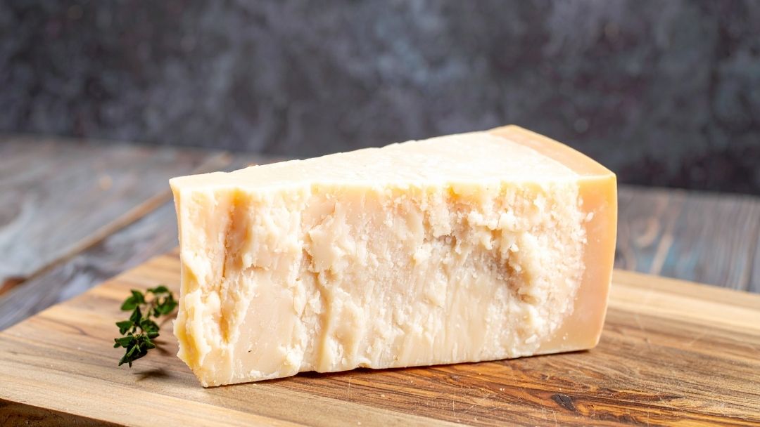 The Cheese Man Parmigiano Reggiano cheese wedge with natural rind and crumbly texture, a premium aged Italian hard cheese ideal for grating and cheese boards.