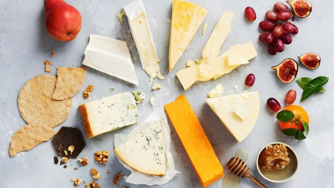 Six iconic artisan cheeses arranged with crackers, fruit and honey, celebrating the essential flavours every cheese lover should experience.