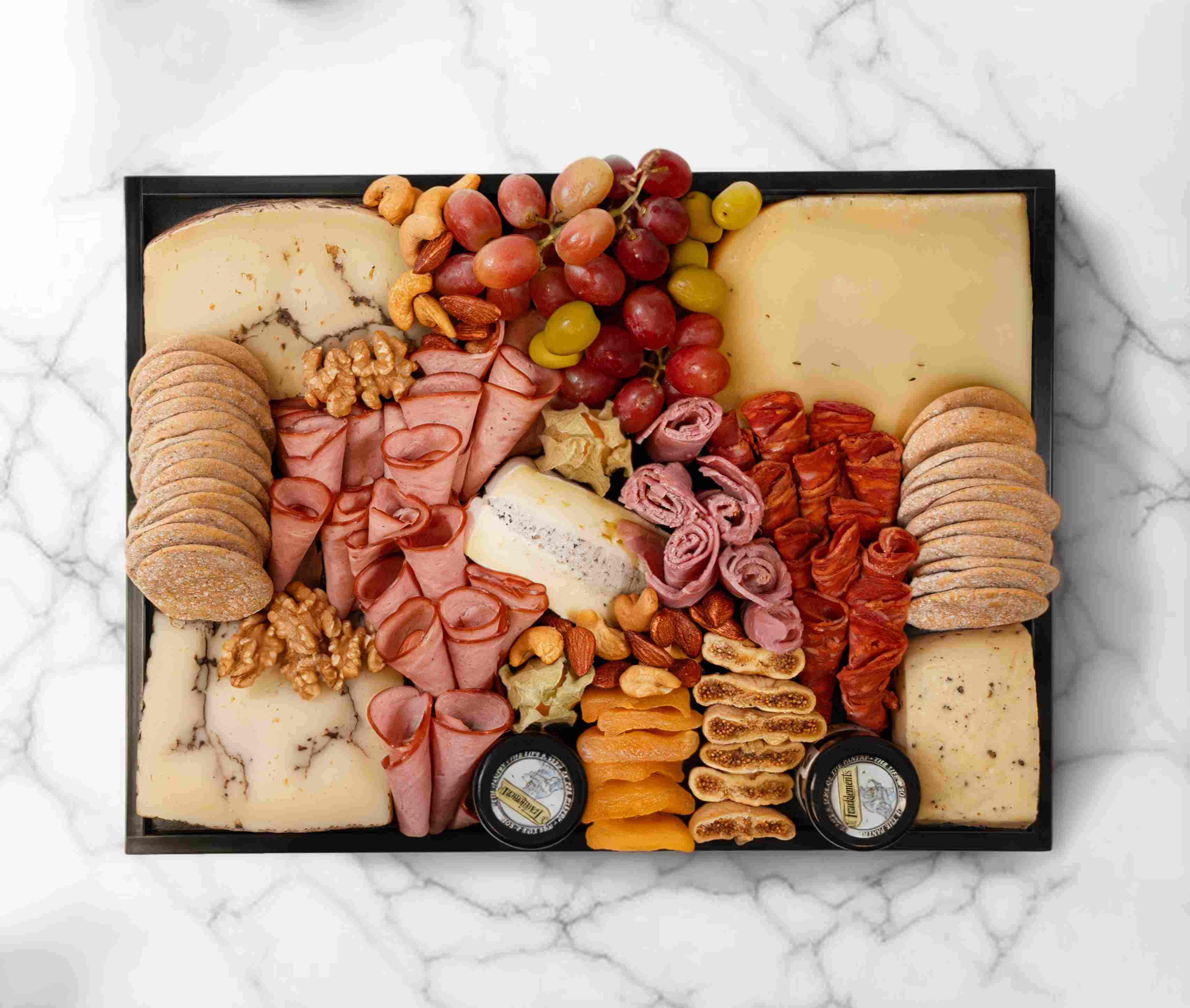 Medium truffle cheeseboard with specialty cheeses and accompaniments, serving 5–7 people.
